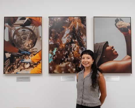 Thalia Juarez poses in the Guardian’s New York office with photos produced with support from last year’s Outrider fellowship.
