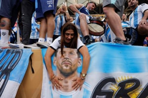 An Argentina fan touches a Lionel Messi flag.