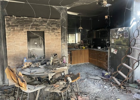 Charred walls and ceilings, and debris in a kitchen