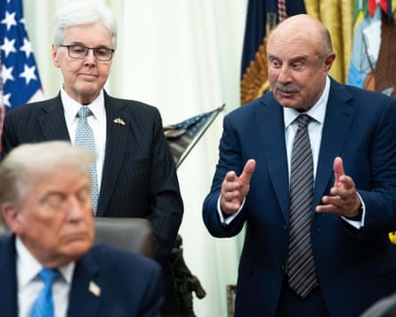 Phil McGraw stands behind Donald Trump in the Oval Office