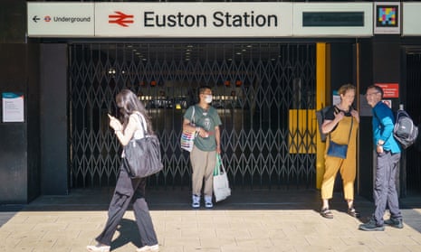 People stand outside the closed entrance to Euston station in London on Saturday.