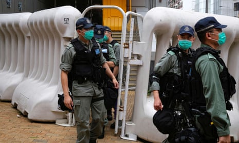 Riot police patrol near China’s liaison office in Hong Kong