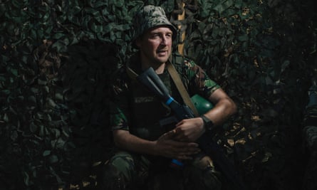 Yevhenii Kostohryz crouches against a camouflage background