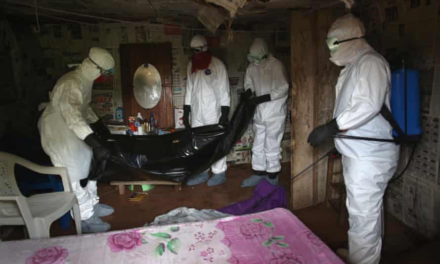 A burial team retrieve the body of a 60-year-old Ebola victim from his home near Monrovia, Libera, in August 2014