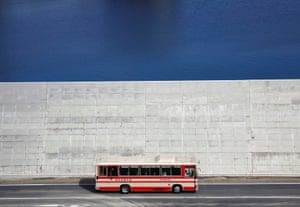 A bus drives past a sea wall in Yamada