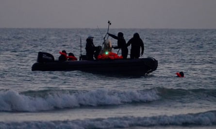 they wear orange lifevests and are on a small rubber dinghy in shallow water.