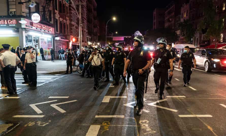 Police watch as hundreds of people protest in New York.