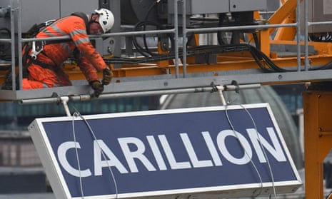 A worker takes down a sign showing the name of liquidated British construction and outsourcing group Carillion from a crane on a building site in London in 2018
