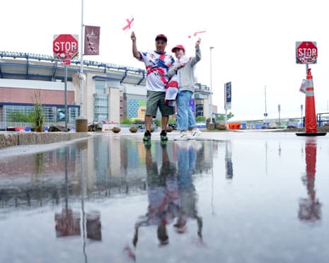 Fans reflected in a puddle outside the stadium.