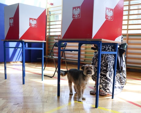 A person with her pet votes in the second round of the Presidential election in Warsaw, Poland.