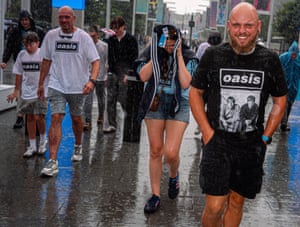 Oasis fans getting drenched in a downpour at Wembley.