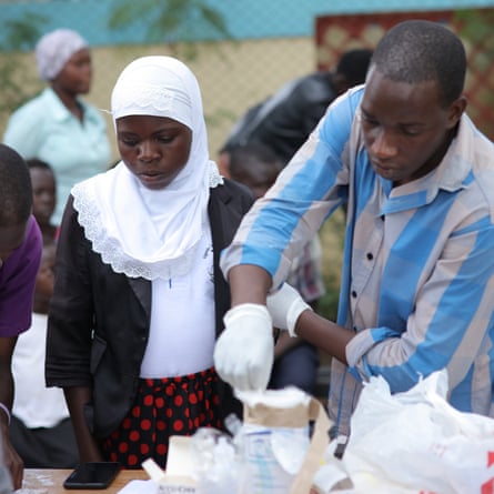 Nurse Jeofrey Ojilong giving a warrior their vitals at a camp in Lira, Uganda.