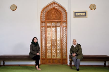 Mishal Husain and her mother, Shama, sitting on wooden benches either site of an intricately carved arched door in Bukhara