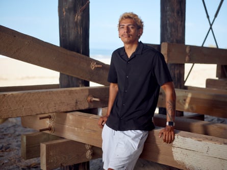 a young man stands for a portait beneath a pier where he likes to spend time