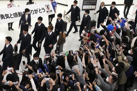 Supporters use smartphones to record the Japanese national soccer team returning home.