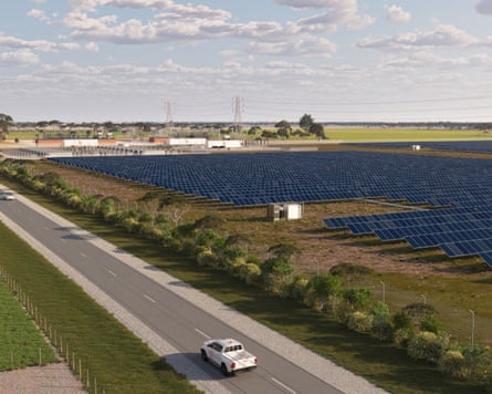 A car drives by a field of solar panels