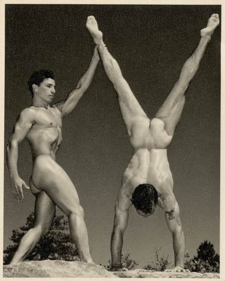 Two nude men posing, one in a handstand