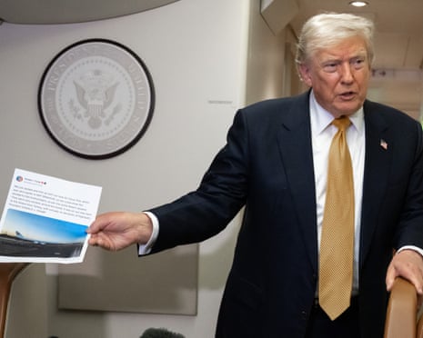 a man in a suit holds a printed piece of paper