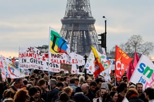 Demonstrators holds banners as they gather on the Place de la Concorde near the National Assembly in Paris, with the Eiffel Tower in the background