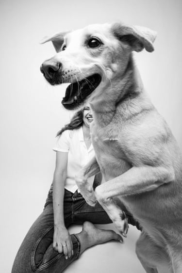 A dog on two legs with a smiling woman in the background