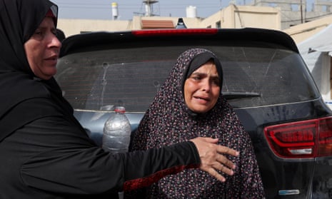 A mourner is comforted as she grieves during the funeral of Palestinians killed in an Israeli strike, at Al-Aqsa hospital in Deir Al-Balah.