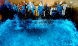 Fishermen trawl a net containing glowing firefly squid off the coast of Namerikawa city in Japan.