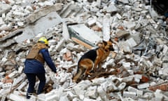 Rescue worker and a sniffer dog search through rubble in Chernihiv.