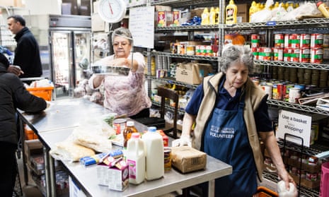 NEW YORK, NY - November 23rd, 2015: Milagros Feliciano, left, and Zoila Estrella, right, volunteers at the West Side Campaign Against Hunger, check recipients out in the food pantry on Monday morning. CREDIT: Alex Welsh for The Guardian