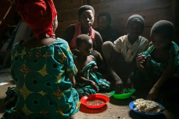 A family fleeing from DRC sit to eat at the Nyakabande transit centre.