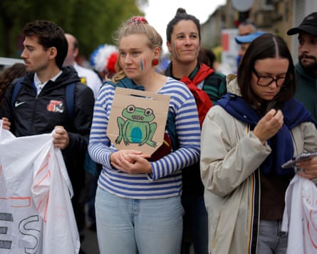 A France fan waits for the team bus holding a picture of a frog with vampire teeth, relating to the banning of flanker Axelle Berthoumieu for biting in the French quarter-final win over Ireland, before the Women’s Rugby World Cup 2025 semi-final match between England and France.