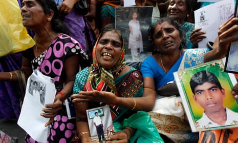 Tamil women cry as they hold up images of their disappeared family members during the country’s civil war.