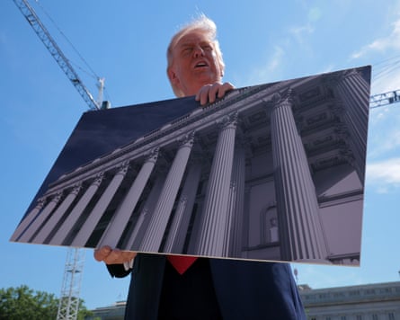 Donald Trump holds artists’ renderings of the White House plans.