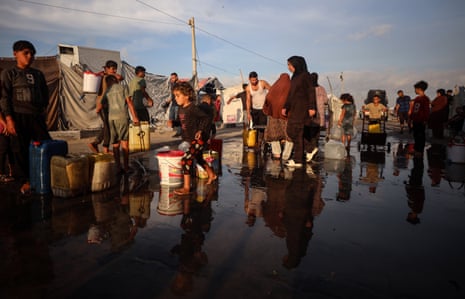 Displaced Palestinians fill jerrycans at a water distribution point in Gaza City on Tuesday.