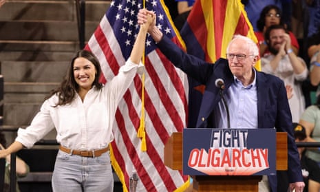 man and woman raise clasped hands at a rally with an american flag behind them