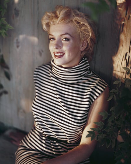 Marilyn Monroe sitting on a bench.