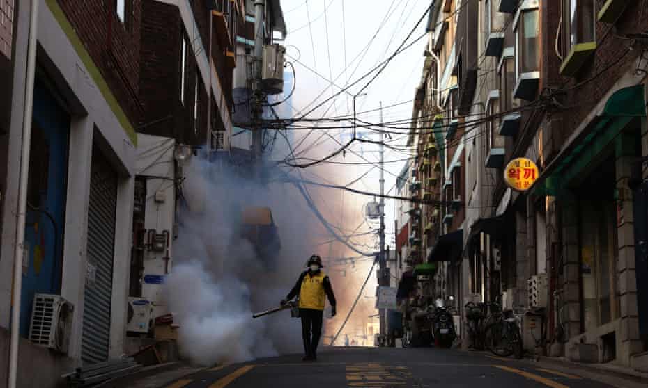 A man disinfects a street in Seoul, South Korea, on 18 March 2020: ‘South Korea has been effective in controlling its mortality rate through widespread rigorous measures.’