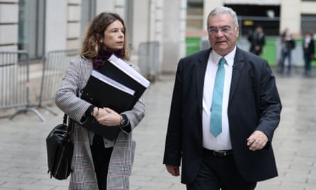Clémence Bectarte walking, holding two large files, alongside Obeida Dabbagh in a smart suit and tie.