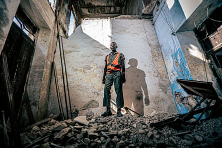 Antonio, 54, a construction worker, poses in his former home at 54 Acosta Street, now in ruins