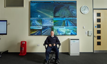 Sean Sloan at the National Highways operations Centre in Surrey, with multiple live screens of roads on the wall behind him