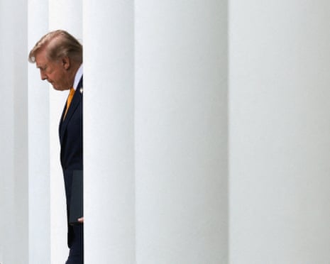 a man in a suit walks with his head down