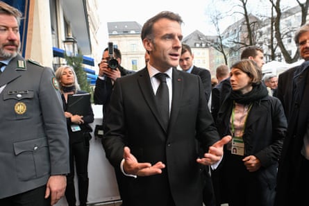 Macron outside a building surrounded by his entourage