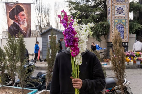 A vendor sells flowers at a market as people shop in preparation for Nowruz celebrations on 19 March 2026 in Tehran, Iran.