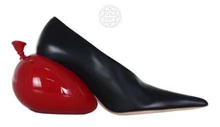 A side-on shot of a pointy black shoe with a deflated shiny red balloon-shaped heel