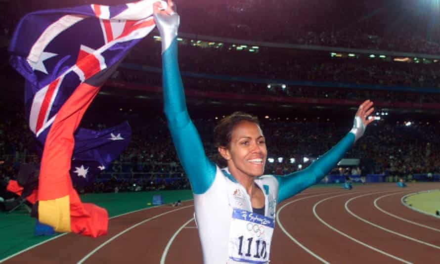 Freeman carries the Aboriginal and Australian flags during her victory lap