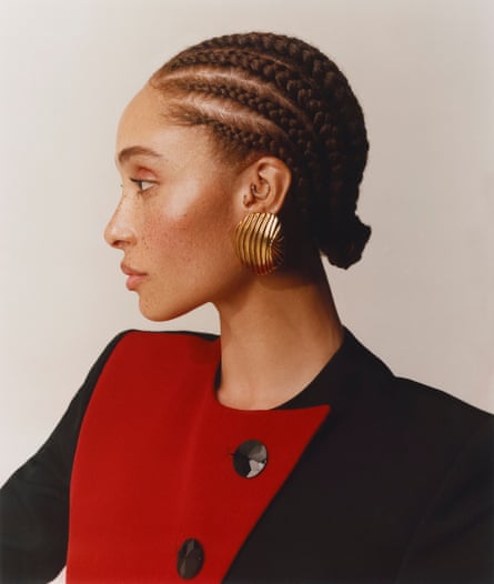 A profile portrait of Adwoa Aboah, wearing a red and black colour block jacket by Saint Laurent
