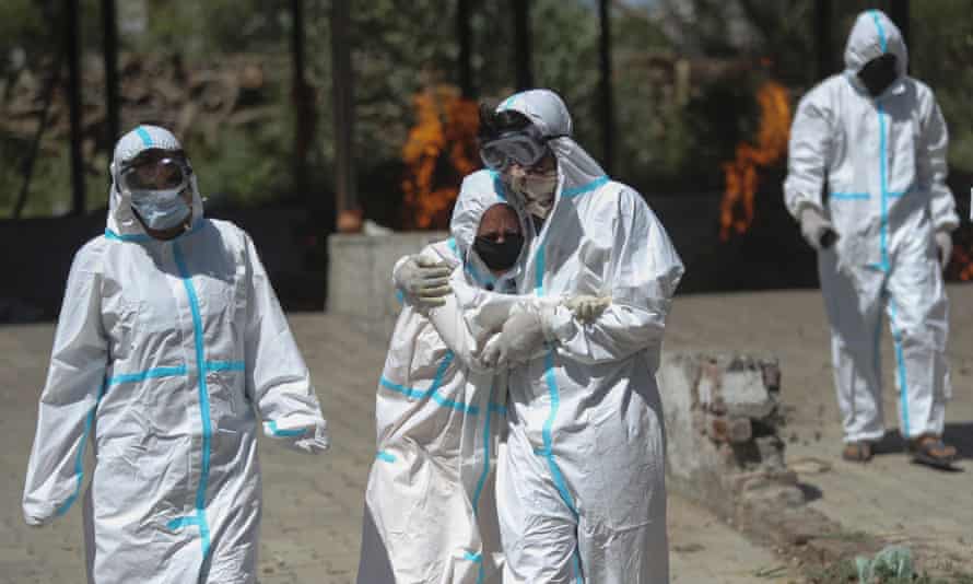 Relatives of a Covid-19 victim at a crematorium in Jammu, India. Relatives of a Covid-19 victim at a crematorium in Jammu, India.