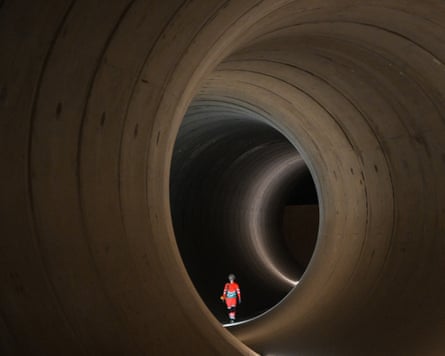 A civil engineer walks inside a concrete tunnel at the Thames Tideway building site, in west London