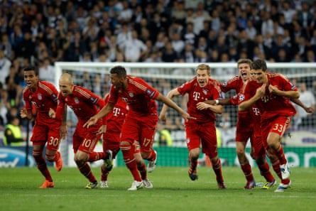 Bayern players race toward the scorer of the winning penalty looking jubilant