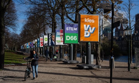A woman walks past campaign posters in The Hague, Netherlands