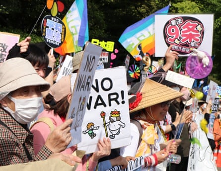 Protesters hold signs supporting Japan’s pacifist constitution and opposing the war in Iran during a demonstration outside the country’s parliament in Tokyo on 19 April.